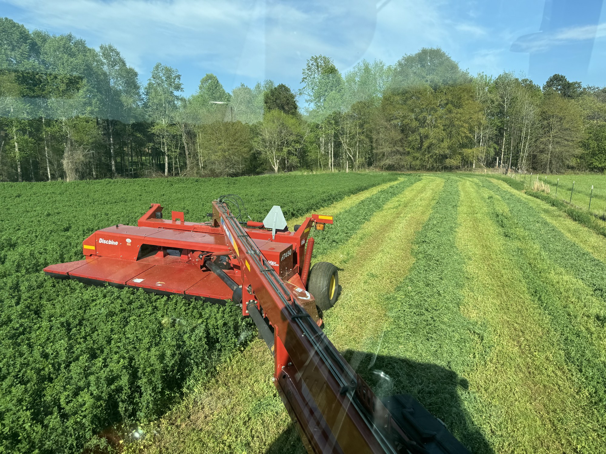 Discbine mower cutting Alfalfa into windrows