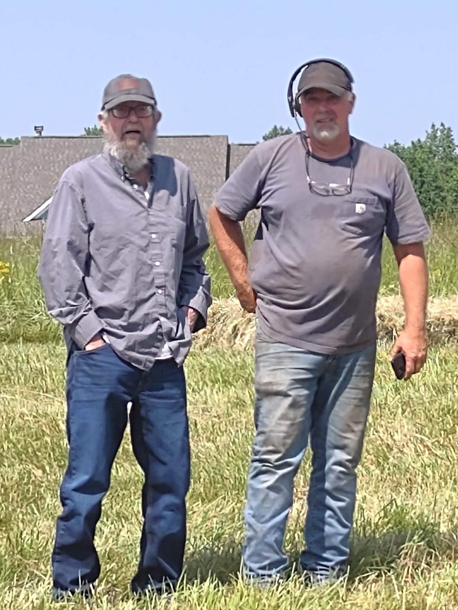 Two members of the Warbridge crew in a freshly cut hay field